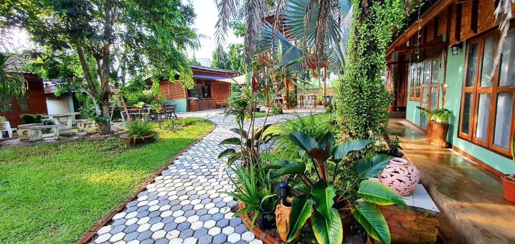 a garden with plants and a building at Baan Suan Taboon Homestay in Chiang Rai