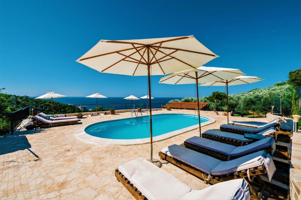 a pool with lounge chairs and umbrellas at Holiday Park Olive Tree in Ulcinj