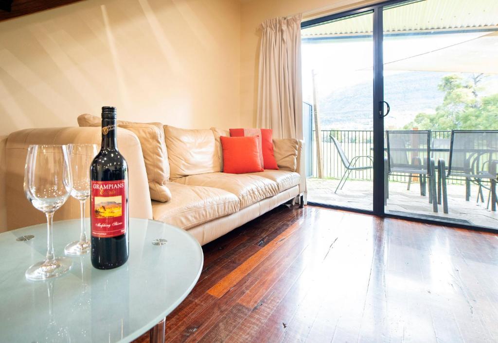 una bottiglia di vino seduta su un tavolo in soggiorno di Halls Gap Townhouse Escape a Halls Gap
