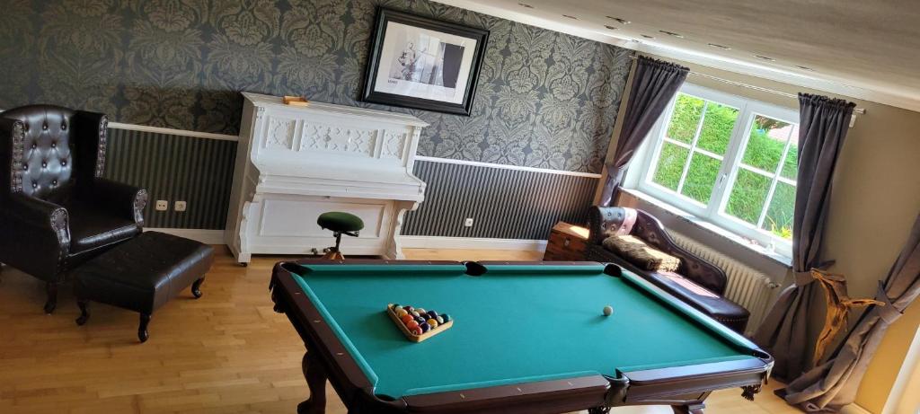 uma sala de estar com uma mesa de bilhar e uma lareira em Stilvolles Apartment "Romantic" em Neukirchen vorm Wald