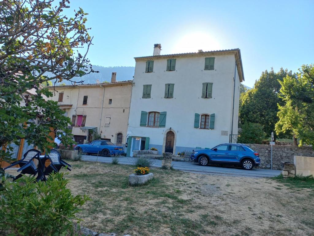 un gran edificio blanco con coches estacionados frente a él en Maison de caractère en La Bastide