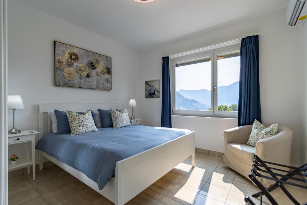 a bedroom with a bed and a chair and a window at Belvedere Apartment Walking Distance from Train Station in Lugano