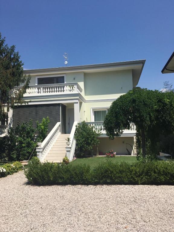 a large white house with stairs and a yard at Villa Romantika in Arco