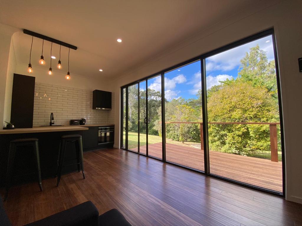 a large kitchen with a large glass door leading to a deck at Kosmo’s Studio: City Style in a Retreat Setting! in Boyland