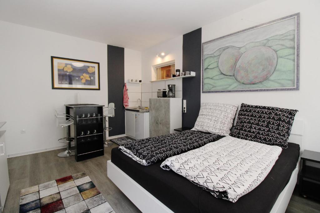 ein Schlafzimmer mit einem schwarz-weißen Bett in einem Zimmer in der Unterkunft Schickes Ferienapartment in Habichtswald-Ehlen in Ehlen