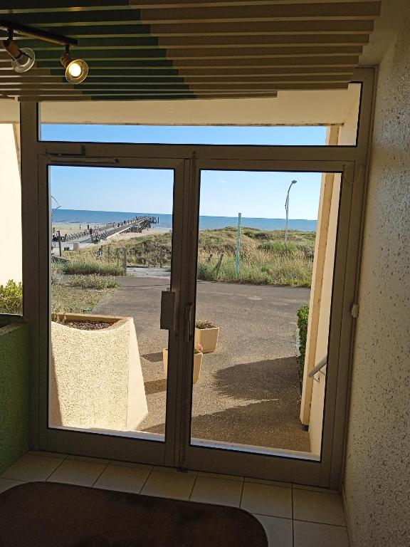 przesuwnymi szklanymi drzwiami z widokiem na plażę w obiekcie Studio RDC - Marina 4 - 13 allée des Pinons - 0-1 w mieście Saint-Jean-de-Monts