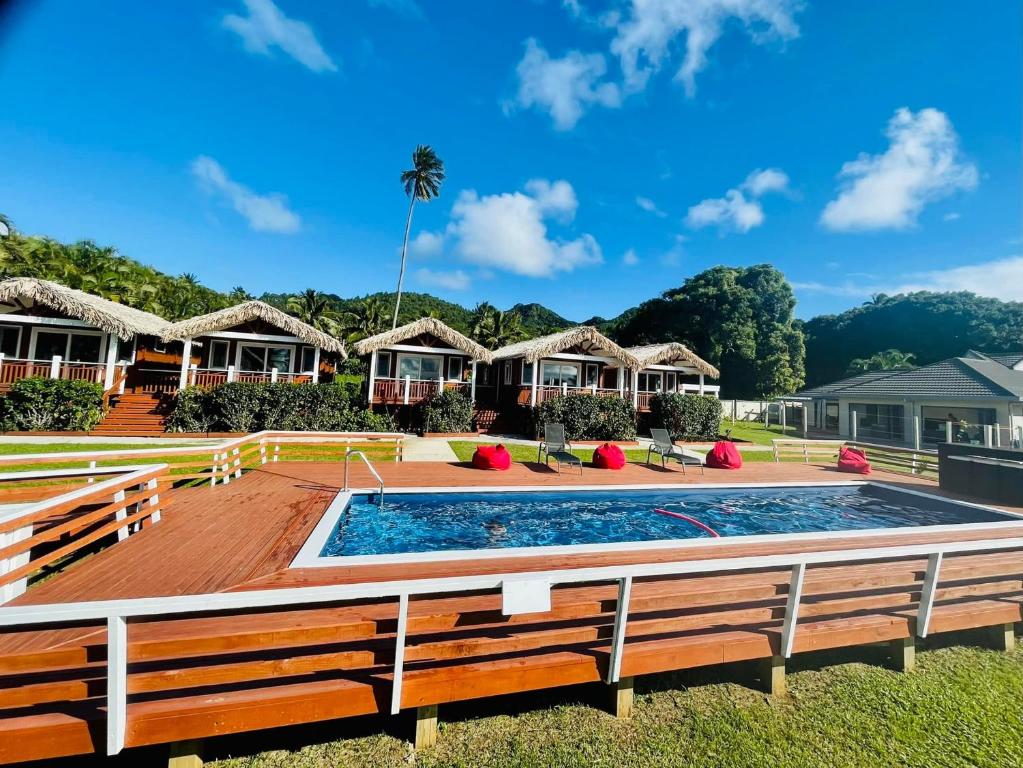 um resort com piscina e várias cabanas em Red Hibiscus Villas em Rarotonga