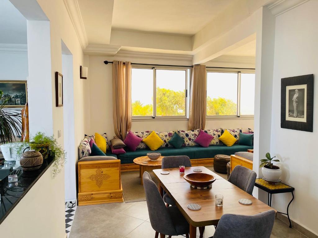 uma sala de estar com um sofá e uma mesa em Chez abdelilah em Oualidia