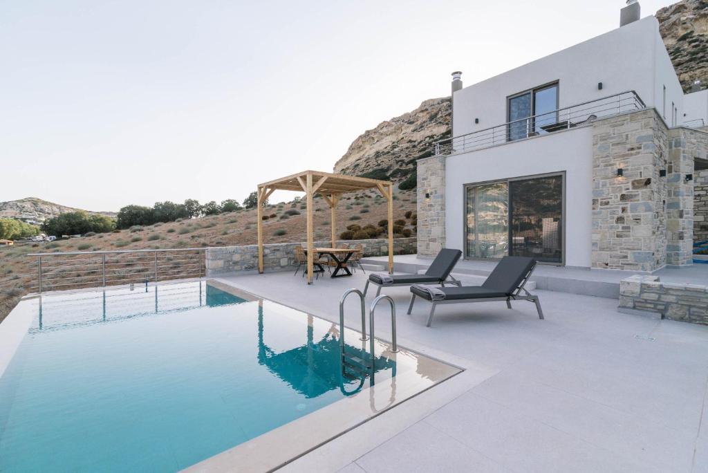 a villa with a swimming pool and a house at Luxury Villas Ammos in Style in Matala