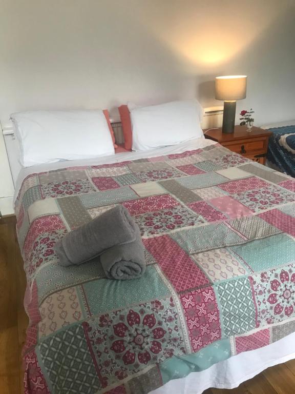 a bedroom with a bed with a quilt on it at City centre rooms Abercorn road ltd free parking free WiFi in Derry Londonderry