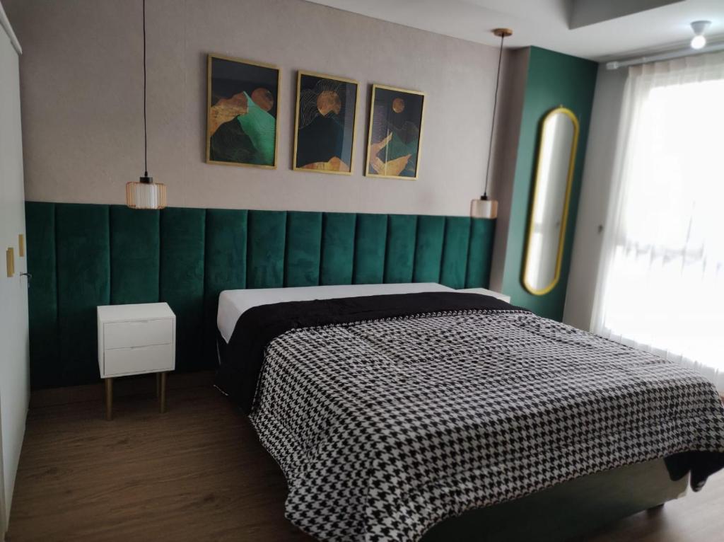 a bedroom with a green wall and a bed at Apartemen Strategis Yogyakarta in Seturan
