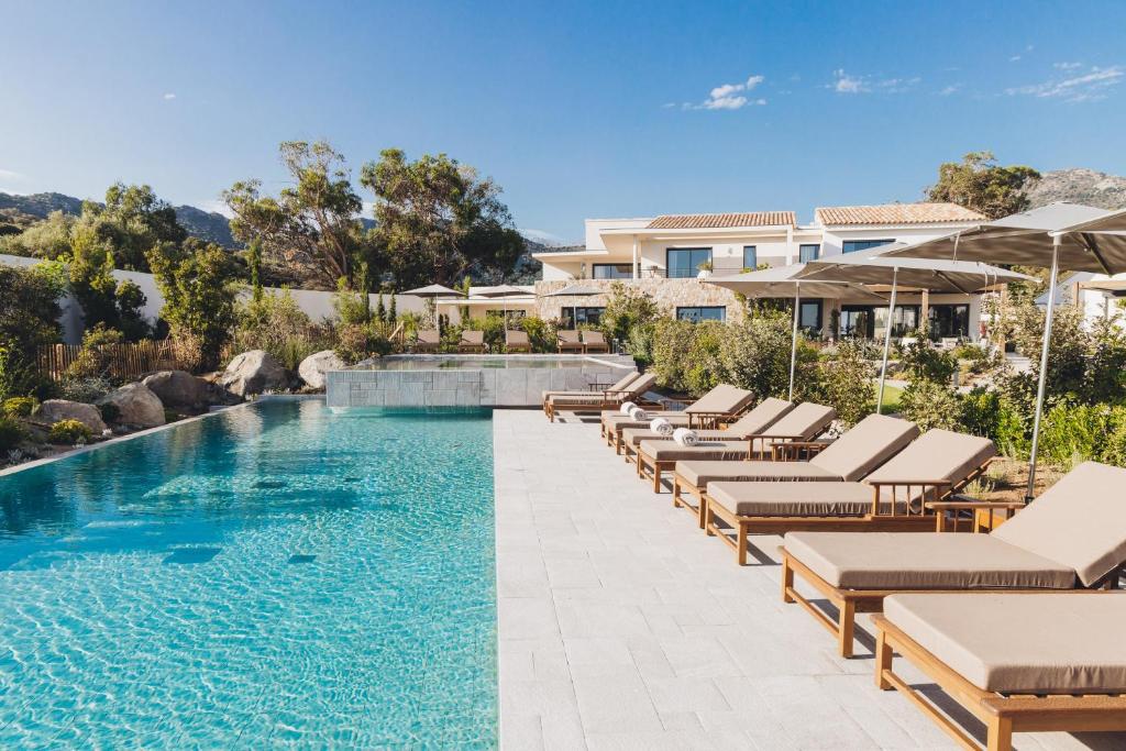 a swimming pool with chaise lounge chairs and a resort at Casa Paradisu in LʼÎle-Rousse