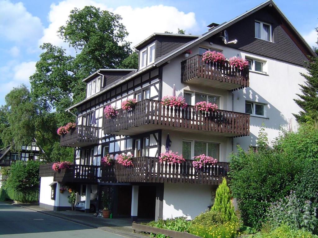 a white building with flower boxes on balconies at Ferienhaus Hedrich in Assinghausen