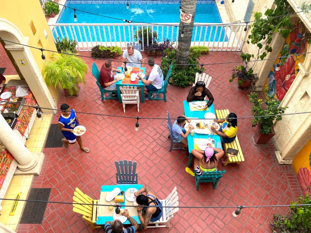 people sitting on benches in front of a restaurant at Hotel Boutique Castillo Ines Maria in Cartagena de Indias