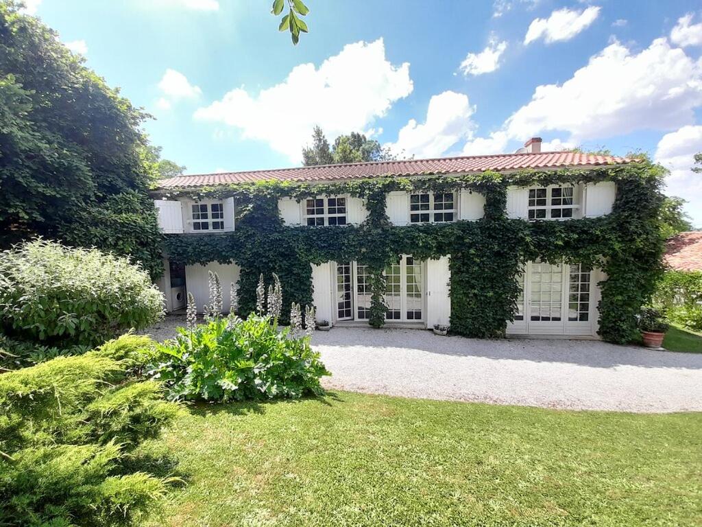 a white house with ivy growing on it at Le Petit Massigny in Velluire