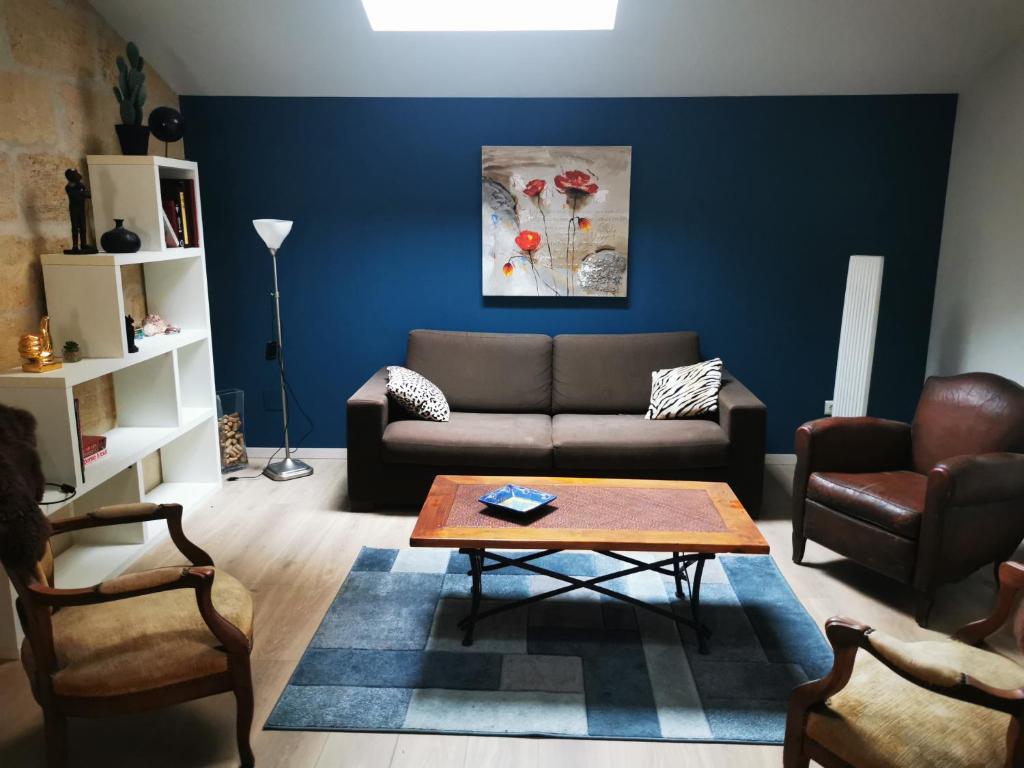 a living room with a couch and a table at APPARTEMENT COSY LIBOURNE in Libourne