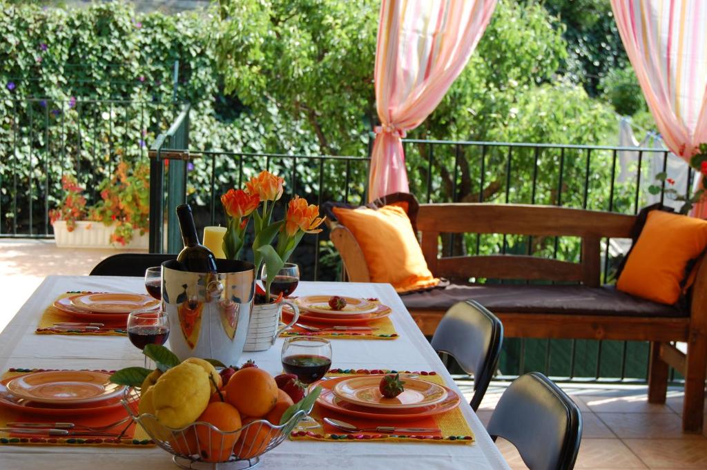 a table with plates of food and a bowl of fruit at Albicocche House in Giarre