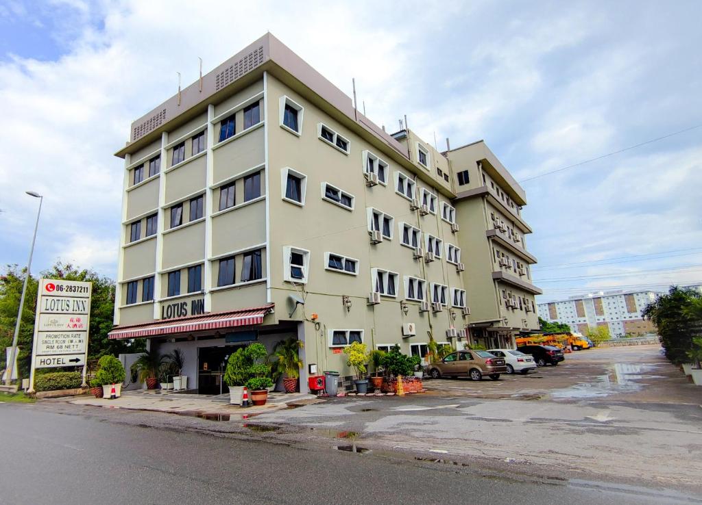 um grande edifício branco no lado de uma rua em Lotus Inn em Malaca