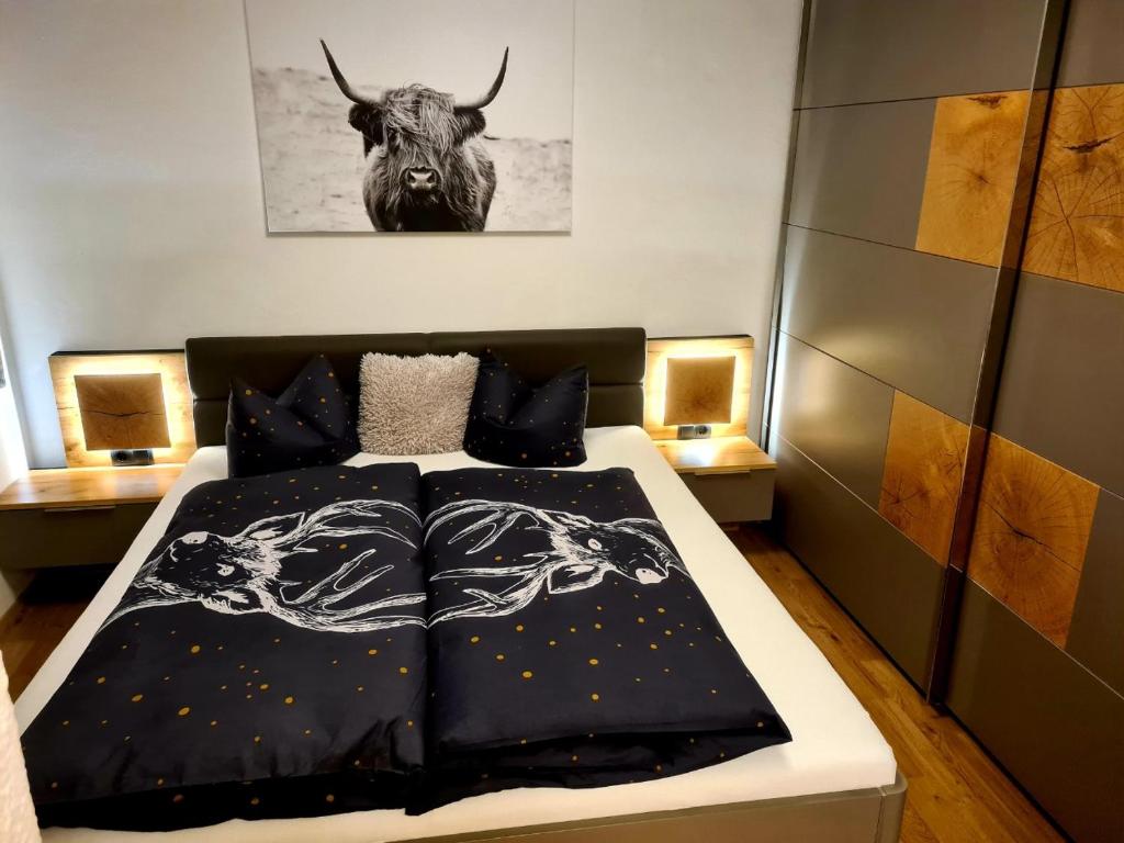 a bedroom with a bed with a bull on the wall at ALPTyrol in Rifenal