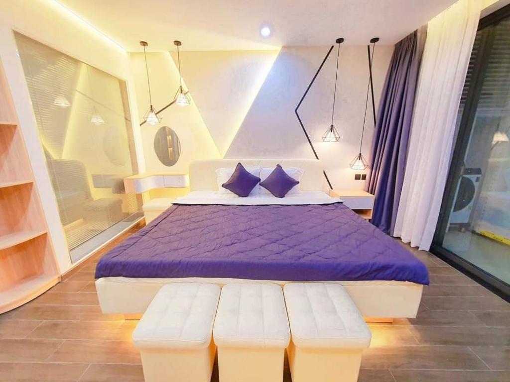 Apec Sunsea Condotel Phu Yen في Liên Trì (3): غرفة نوم مع سرير مع ملاءات أرجوانية ومخدات زرقاء