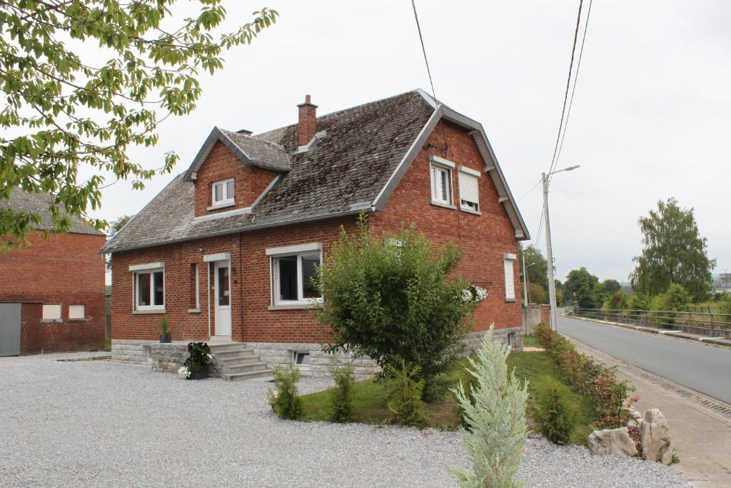 a red brick house on the side of a road at Le Montôbuis in Couvin