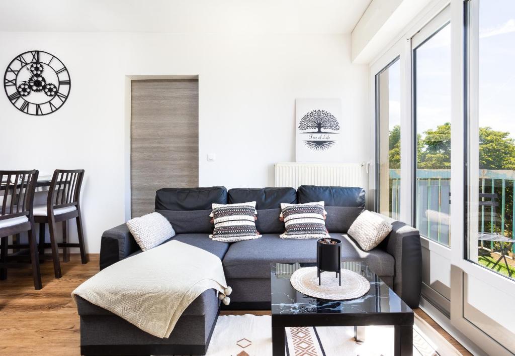 un salon avec un canapé bleu et une table dans l'établissement APPART PREMIUM DU LYS Balcon amenage Parking gratuit, à Dammarie-les-Lys