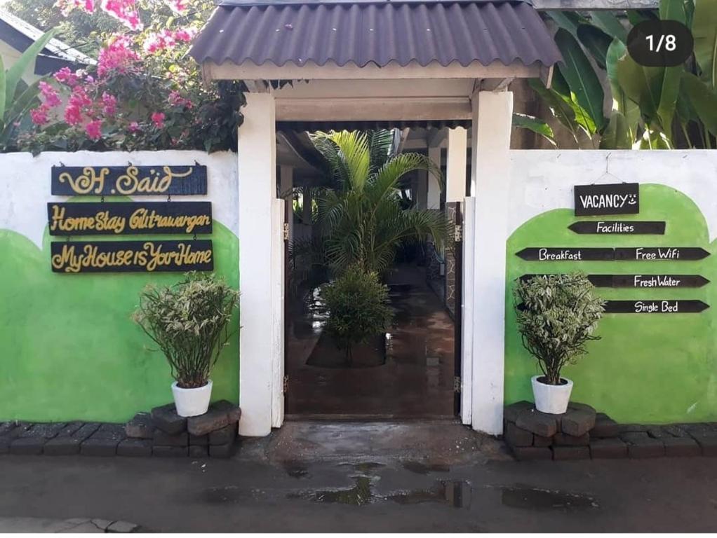 a front door of a house with plants in pots at H.Said Homestay in Gili Trawangan
