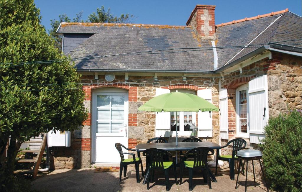 une table avec des chaises et un parasol devant une maison dans l'établissement Gorgeous Home In Pleubian With Kitchen, à Pleubian