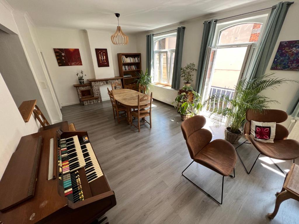 - un salon avec un piano, une table et des chaises dans l'établissement Relax Sax Appartment, à Dinant