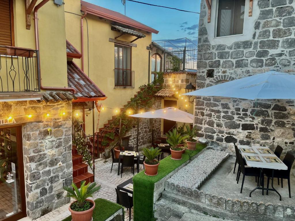 an outdoor patio with tables and chairs and umbrellas at La sosta di Silla in Squille