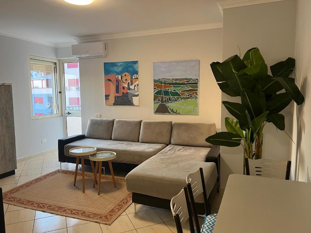 a living room with a couch and a table at Lungomare Rei's Apartment in Durrës
