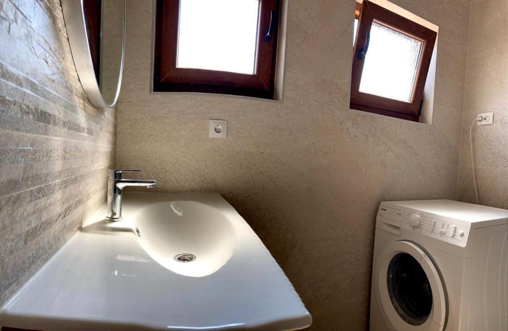 łazienka z umywalką i pralką w obiekcie Studio apartman Luka w mieście Starigrad-Paklenica