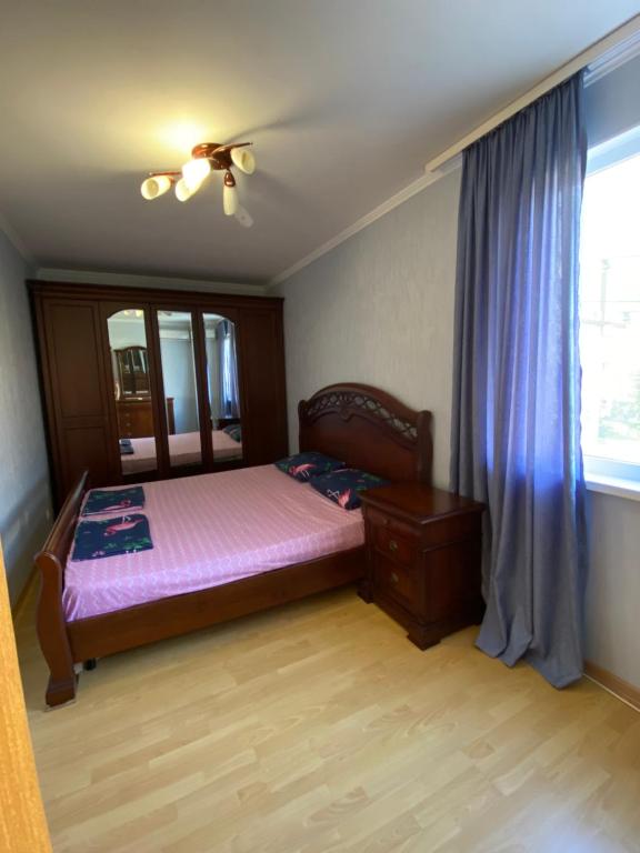 a bedroom with a bed and a window at Apartment on Abazgaa in Gagra