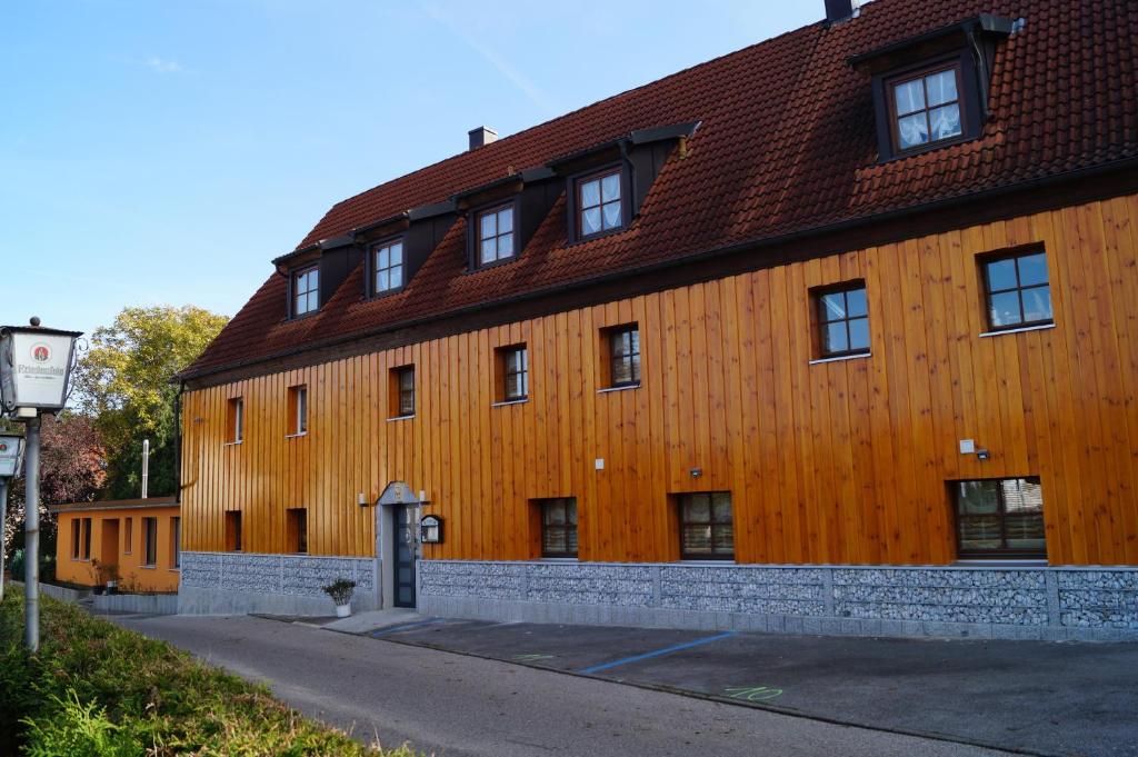 un gran edificio de madera con techo rojo en Gelber Löwe B&B Nichtraucherhotel, en Schwabach