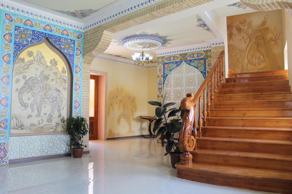 a person walking down a staircase in a building with tiles at Mevlana Hotel in Samarkand