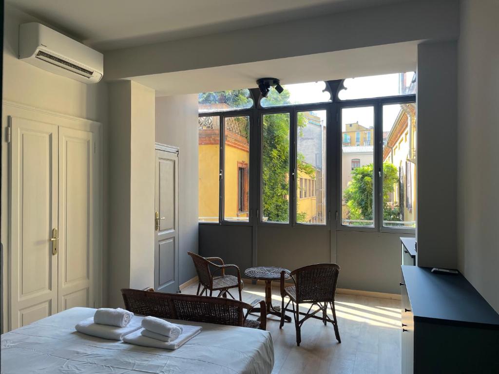 Cette chambre comprend un lit, une table et des chaises. dans l'établissement Ritorno alle origini Suites, à Milan