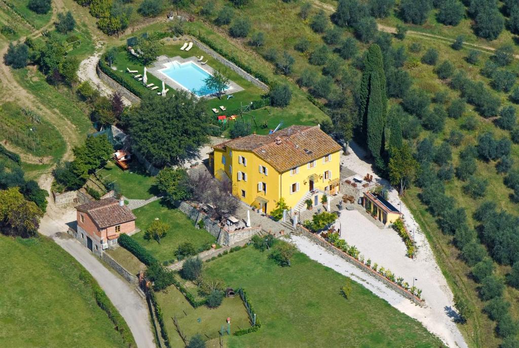 una vista aerea di una grande casa gialla in un campo di Amedea Tuscany Country Experience a Pistoia