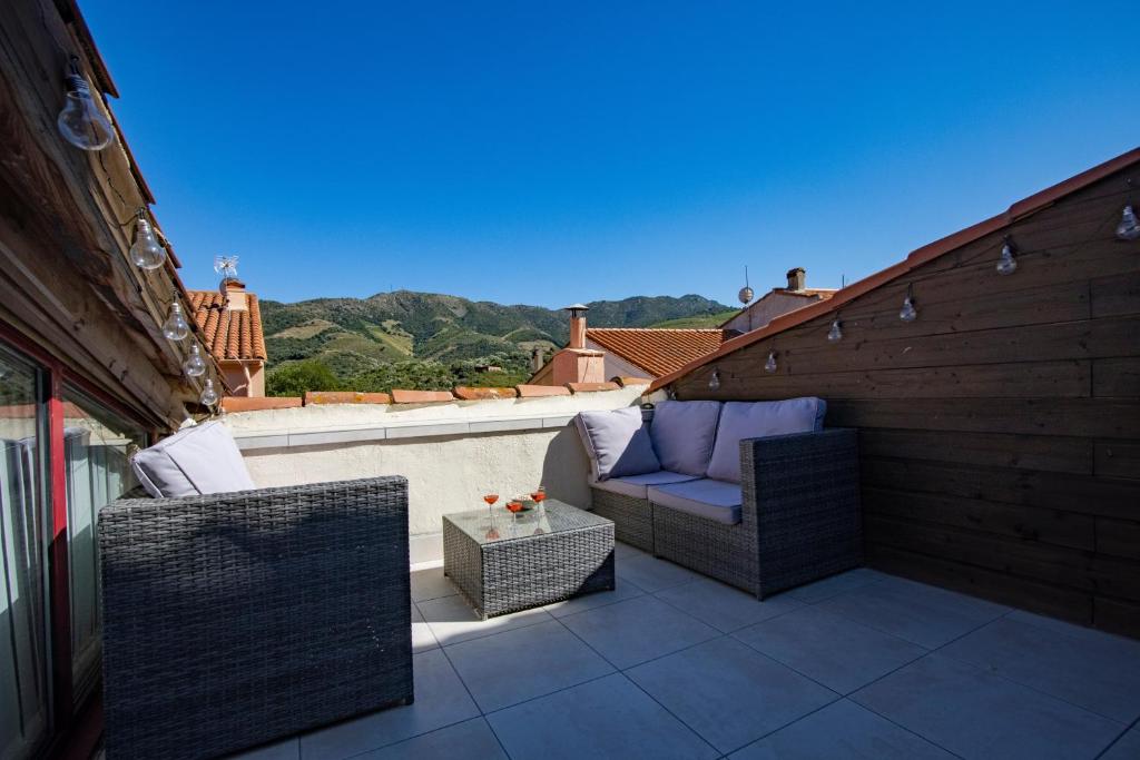 un patio avec deux chaises et une table sur un balcon dans l'établissement La Marinade, à Banyuls-sur-Mer