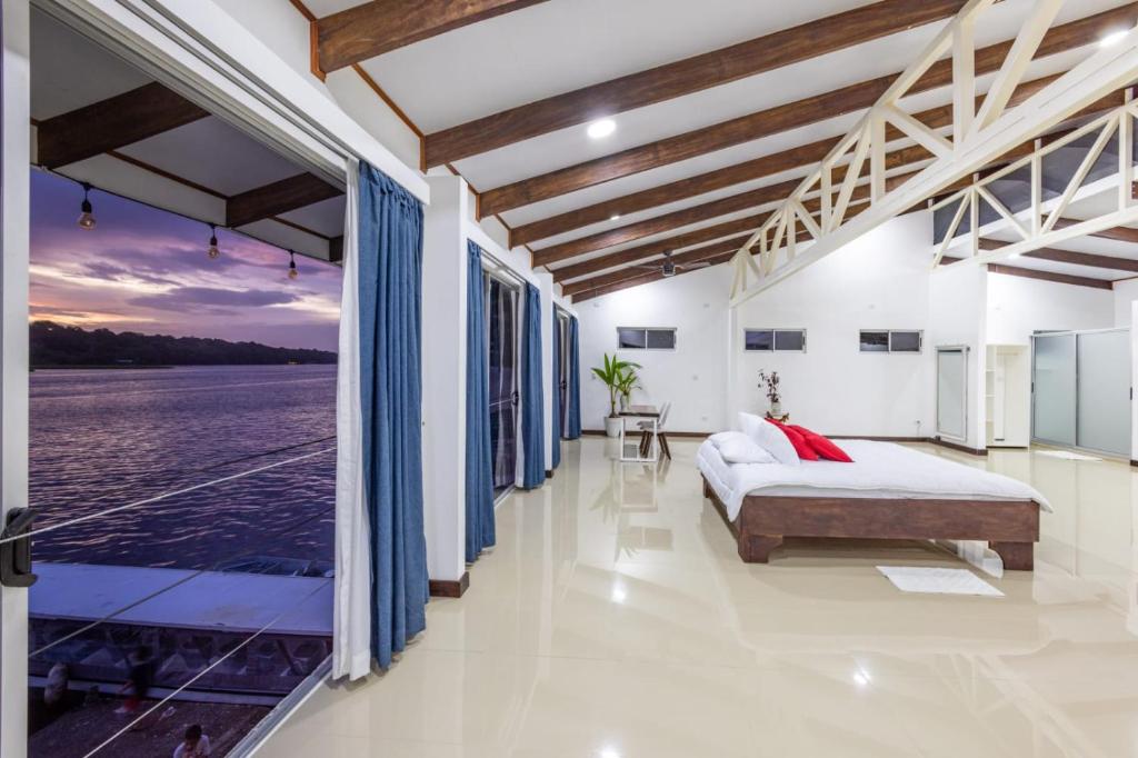 Schlafzimmer mit einem Bett und Blick auf das Wasser in der Unterkunft The Babylon Suite Tortuguero in Tortuguero