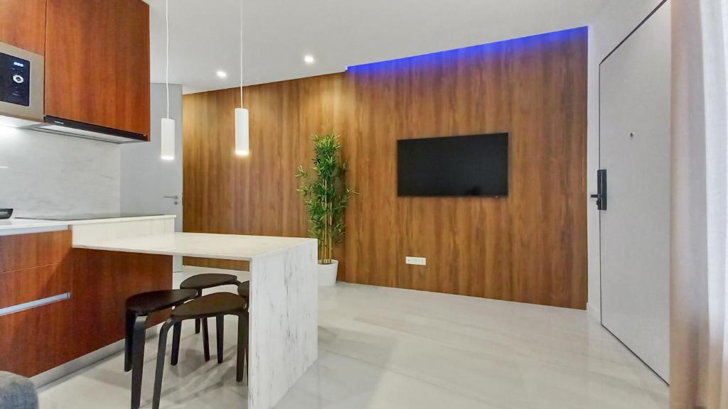a kitchen with a table and a tv on a wooden wall at Seven Seas Apartments in Nazaré
