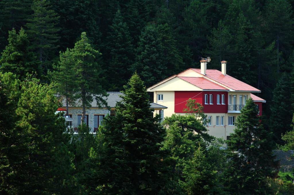 une maison rouge et blanche au milieu des arbres dans l'établissement Salvia, à Loutra Amarantou