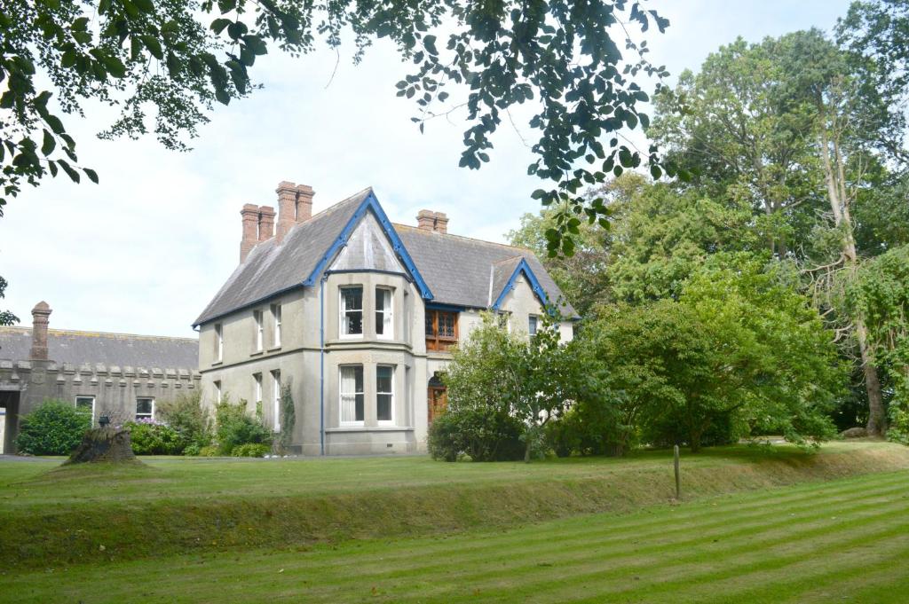 a large white house with a blue roof at Kiltariff Hall Country House in Rathfriland