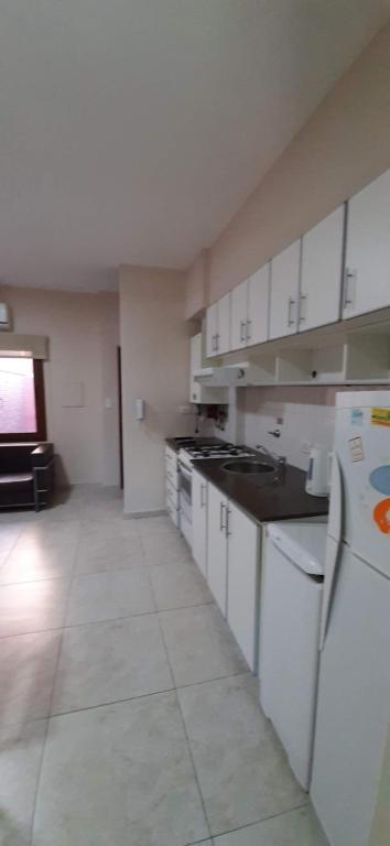 a large kitchen with white cabinets and appliances at DEPTOS BAHIA in Bahía Blanca