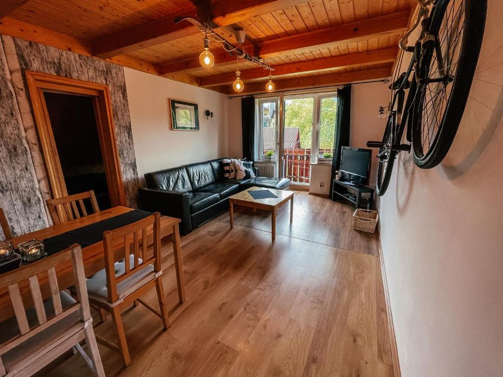 una sala de estar con una bicicleta colgada en la pared en Apartament z DeSki en Bystra