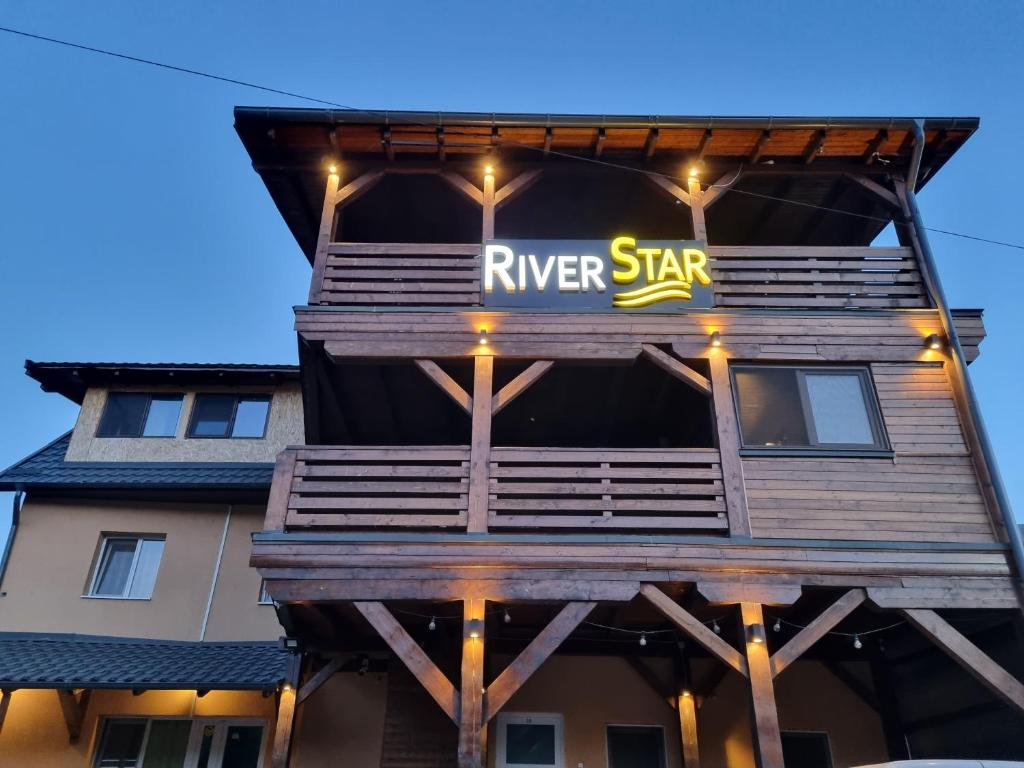 a river star building with a river star sign on it at River Star in Sîngeorgiu de Pădure