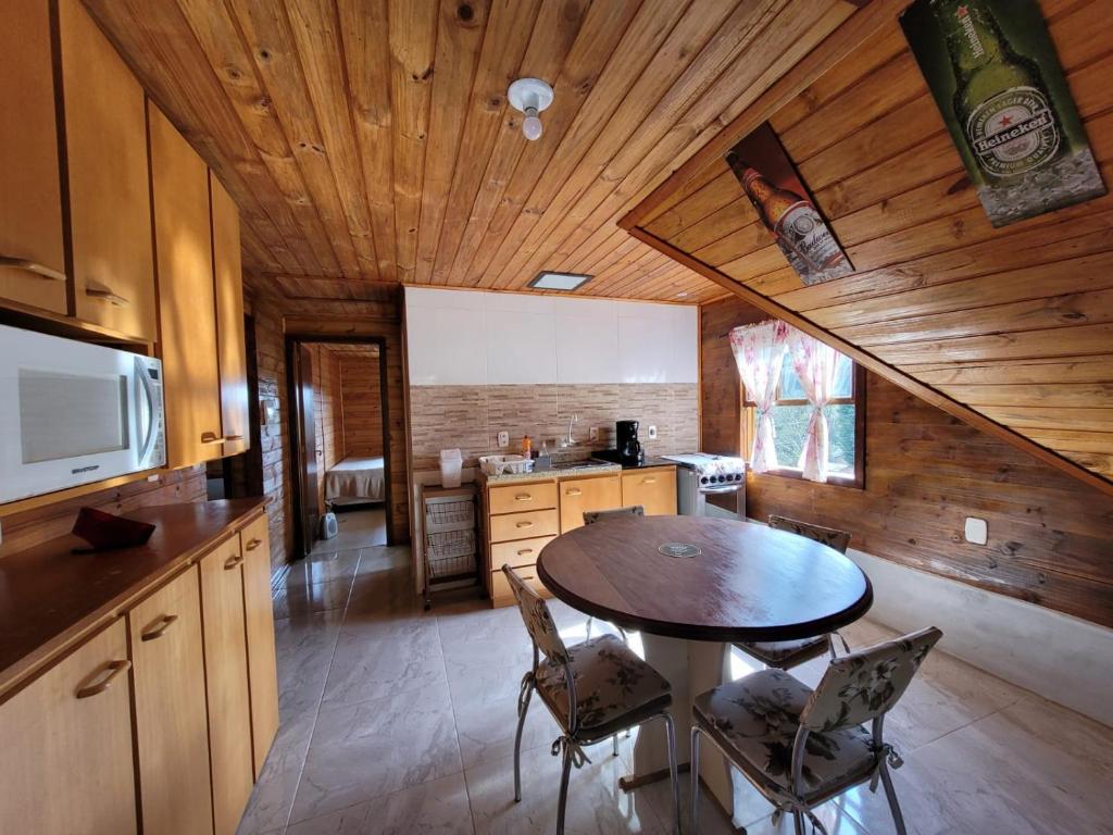 a kitchen with a table and chairs in a cabin at Casa Cabana in Canela