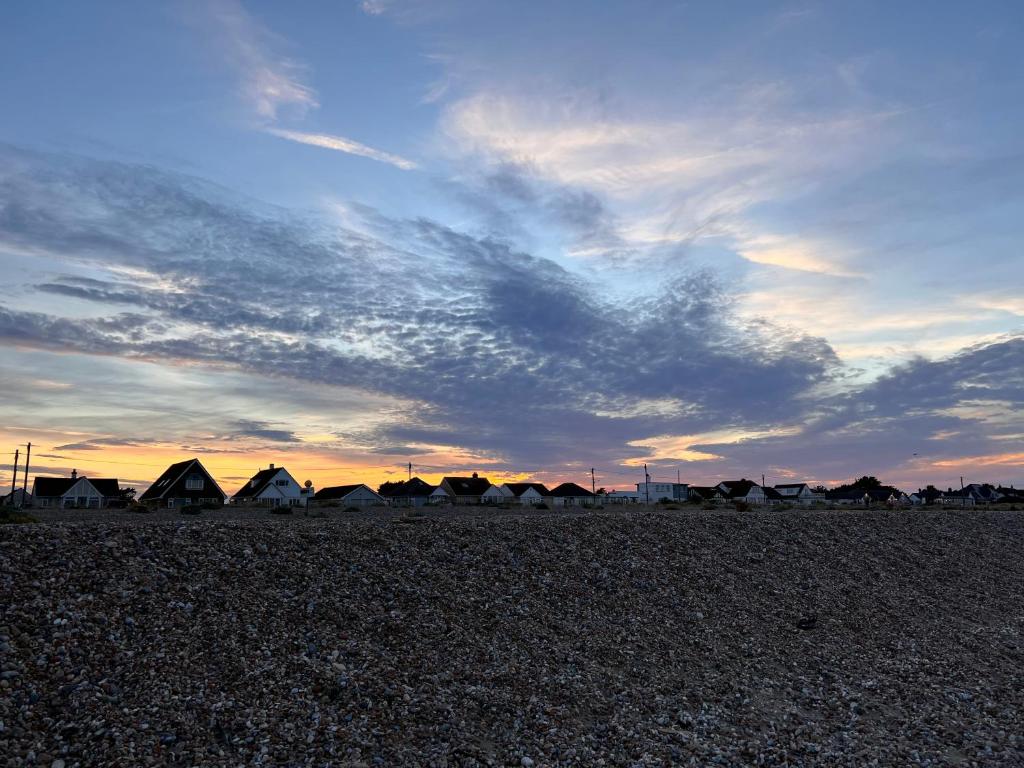 a group of tents on a beach at sunset at holidayhome-romneysands holiday park in Littlestone-on-Sea