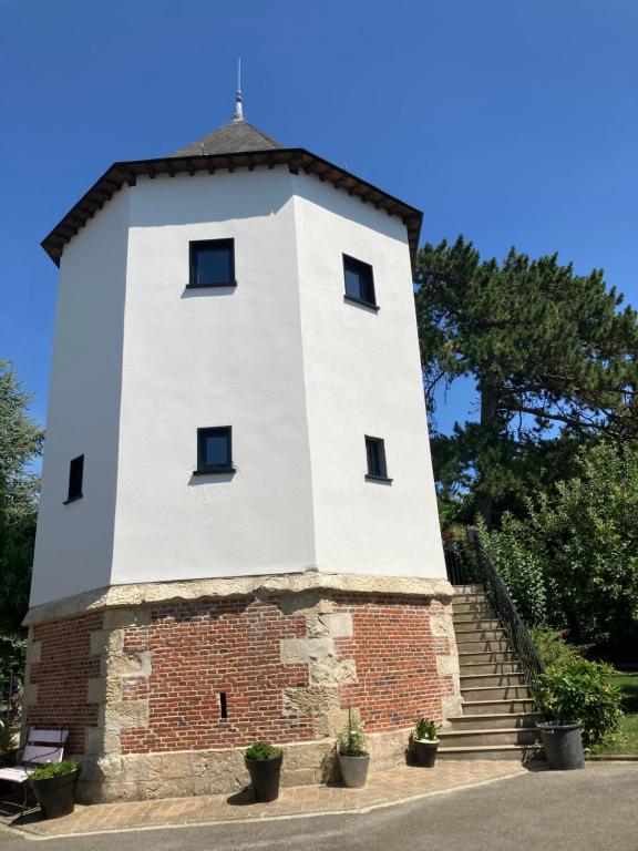 einen weißen Turm mit Treppen auf einem Backsteingebäude in der Unterkunft Le nid 