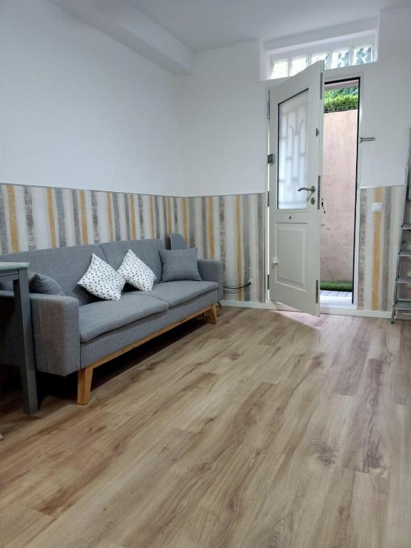 a living room with a couch and wooden floors at Ángeles home in El Vendrell