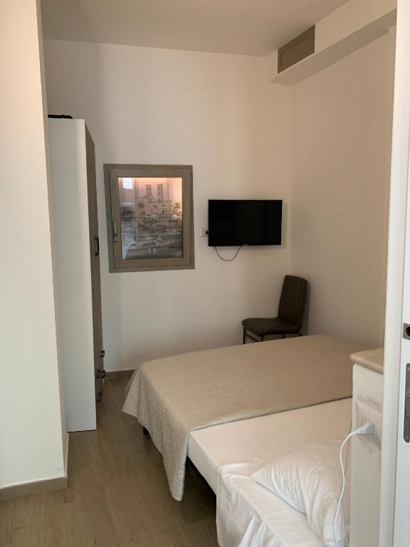 a hotel room with two beds and a television at Sette Torri 2 in Molfetta